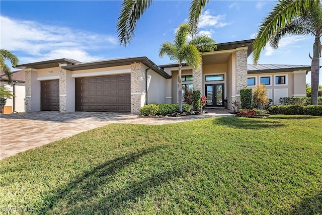 view of front of home featuring a garage, a front lawn, and french doors