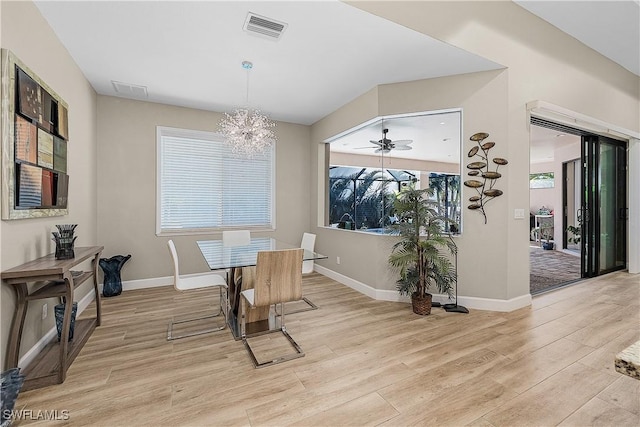 dining space featuring ceiling fan with notable chandelier and light hardwood / wood-style floors