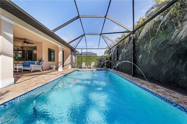 view of swimming pool featuring ceiling fan, a patio, glass enclosure, an outdoor living space, and pool water feature