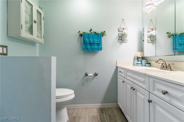 bathroom featuring vanity, toilet, and hardwood / wood-style floors