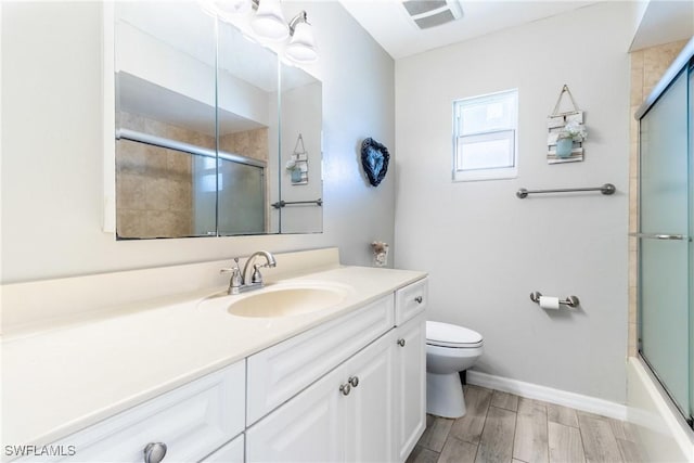 full bathroom featuring vanity, combined bath / shower with glass door, and toilet