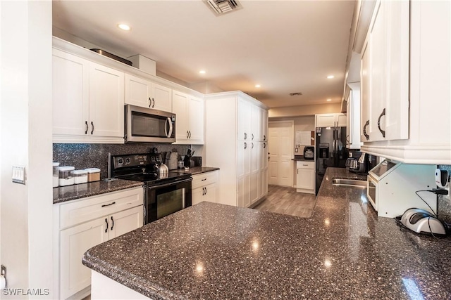 kitchen with white cabinets, dark stone counters, decorative backsplash, and black appliances