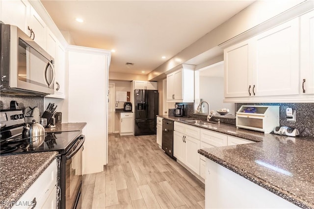 kitchen with sink, white cabinetry, backsplash, dark stone countertops, and black appliances