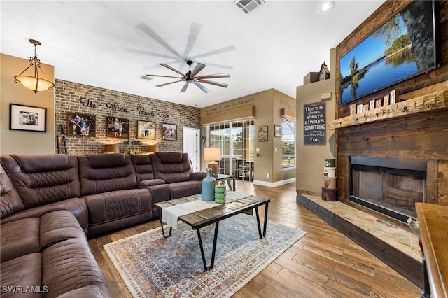 living room featuring ceiling fan, brick wall, and hardwood / wood-style floors