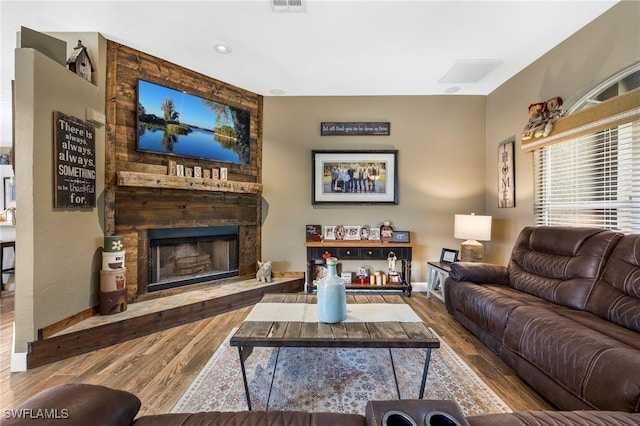 living room with hardwood / wood-style flooring and a large fireplace