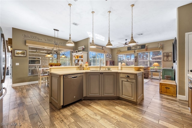 kitchen featuring decorative light fixtures, dishwasher, sink, a center island with sink, and light wood-type flooring