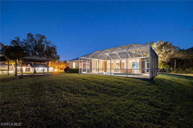 rear view of house featuring a gazebo, a lanai, and a yard