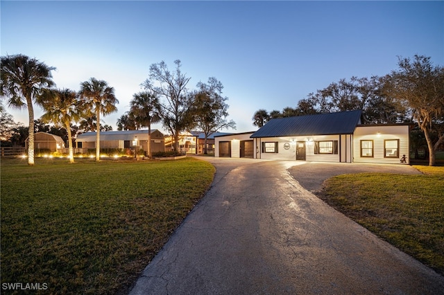 ranch-style home featuring a garage and a lawn