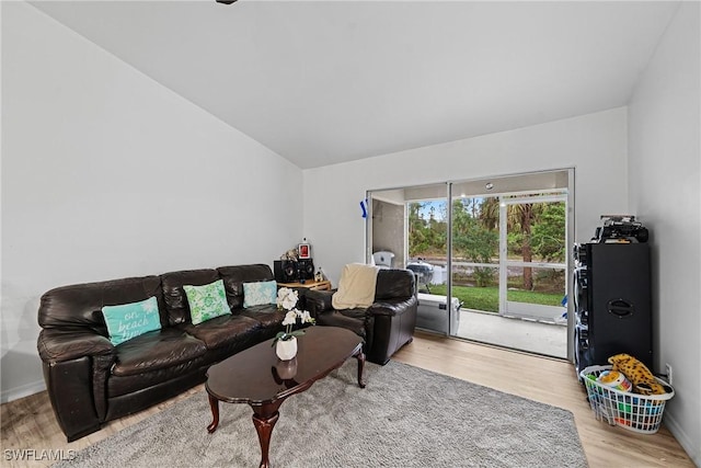 living room with lofted ceiling and light hardwood / wood-style flooring