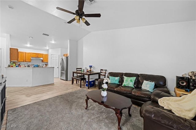 living room with lofted ceiling, ceiling fan, and light hardwood / wood-style flooring