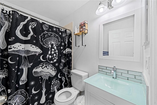 bathroom featuring tasteful backsplash, vanity, and toilet