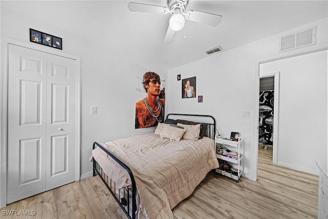 bedroom with ceiling fan, a walk in closet, light wood-type flooring, and a closet