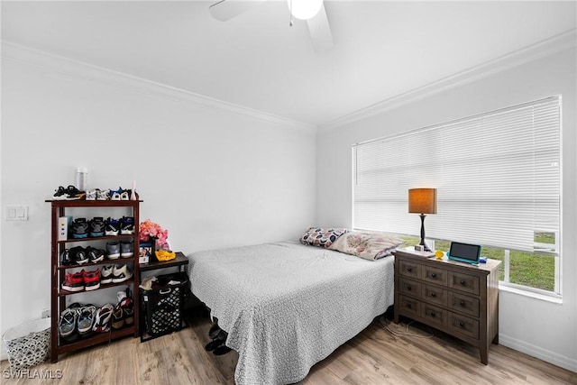 bedroom featuring light hardwood / wood-style flooring, ornamental molding, and ceiling fan