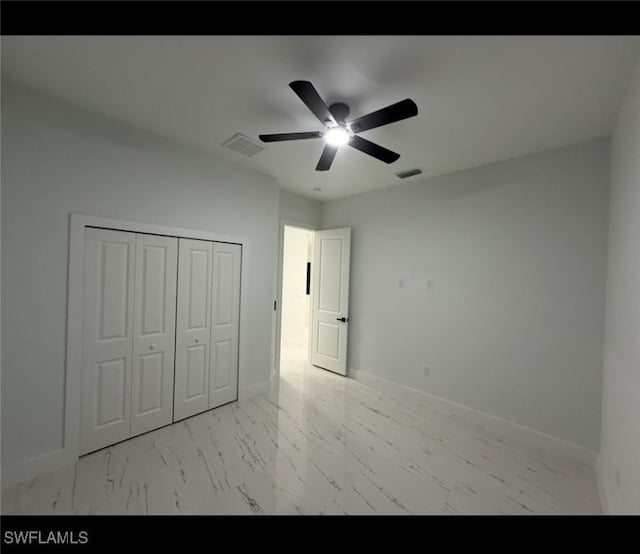 2704 15th St SW, Lehigh Acres, FL 33976 - unfurnished bedroom with marble finish flooring, baseboards, a closet, and ceiling fan