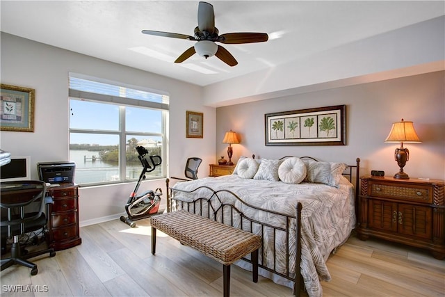 bedroom featuring a water view, ceiling fan, and light hardwood / wood-style flooring