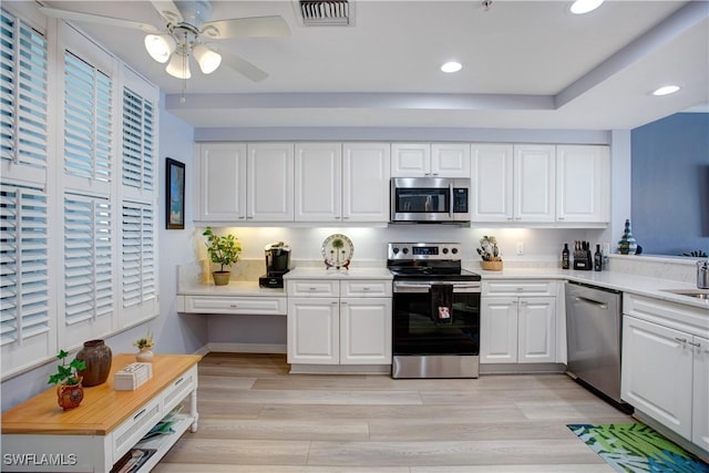 kitchen featuring sink, white cabinets, ceiling fan, light hardwood / wood-style floors, and stainless steel appliances