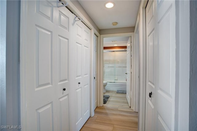 hallway with light hardwood / wood-style floors