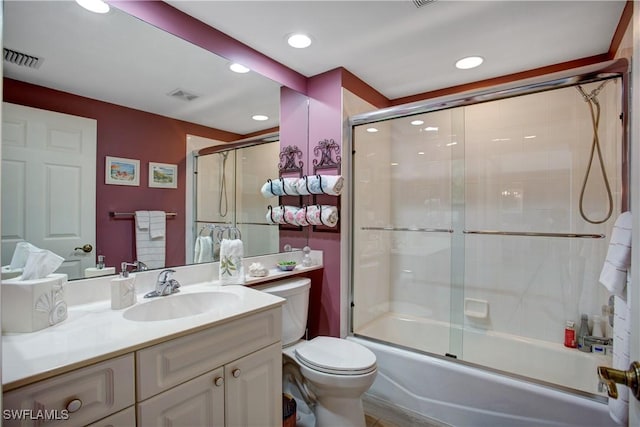 full bathroom with vanity, shower / bath combination with glass door, and toilet