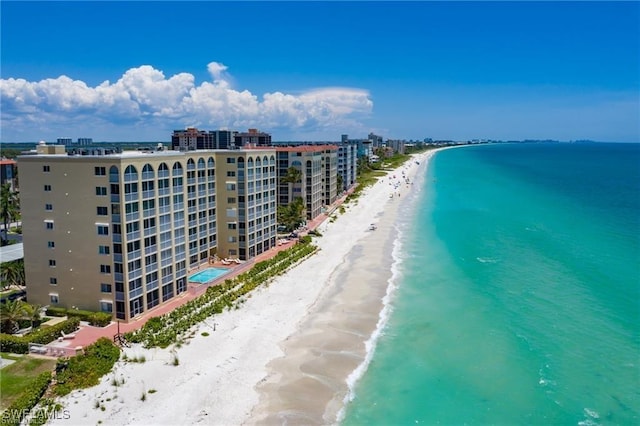 birds eye view of property with a water view and a beach view