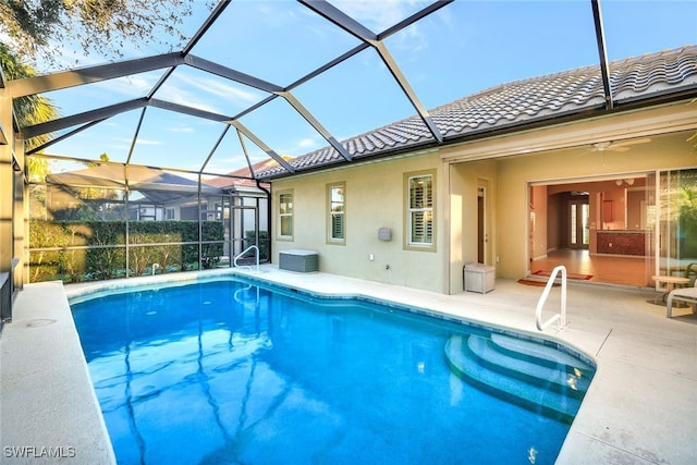 view of swimming pool featuring ceiling fan, a patio, and glass enclosure