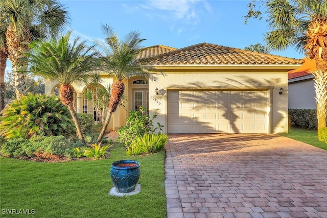 mediterranean / spanish-style house featuring a garage and a front yard