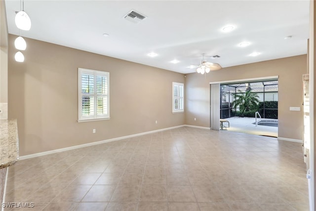 empty room featuring a wealth of natural light and ceiling fan