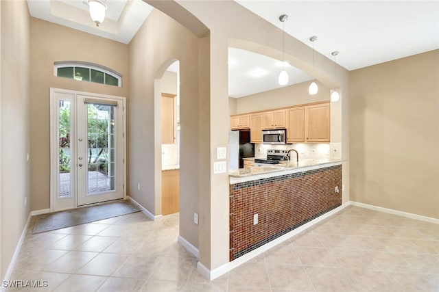 kitchen featuring light tile patterned floors, hanging light fixtures, stainless steel appliances, tasteful backsplash, and light brown cabinetry