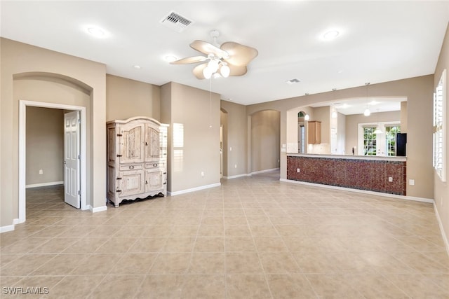 unfurnished living room with ceiling fan and light tile patterned flooring