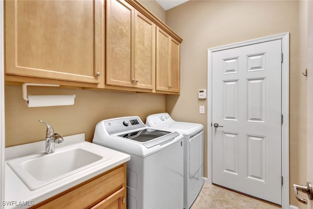 laundry room with sink, washer and clothes dryer, cabinets, and light tile patterned flooring