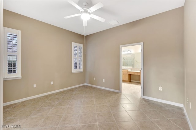 tiled spare room featuring ceiling fan