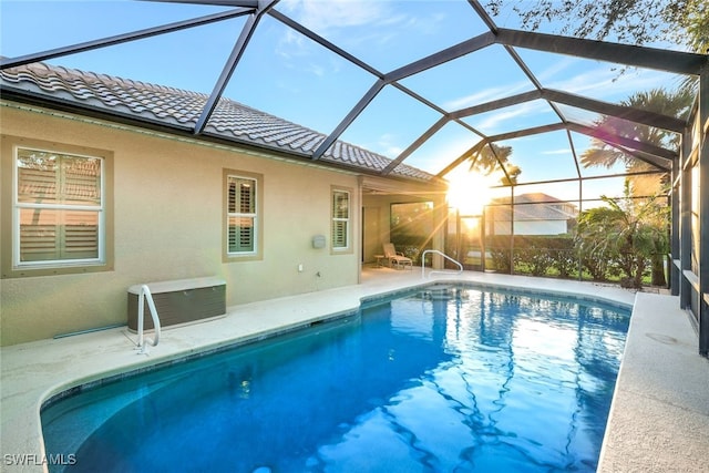 view of swimming pool featuring a lanai and a patio