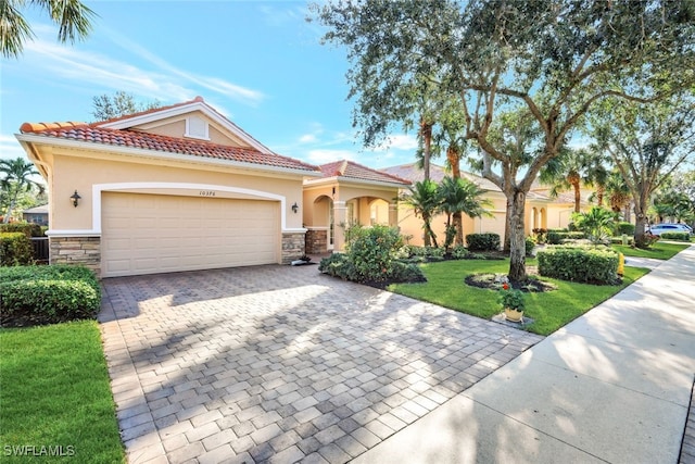 mediterranean / spanish house with a garage and a front yard