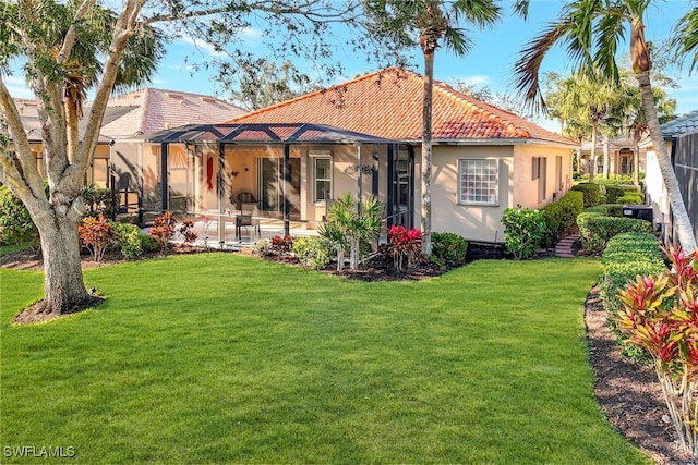 rear view of property with a yard, a lanai, a patio area, and central AC