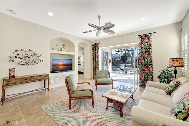 tiled living room featuring built in features and ceiling fan