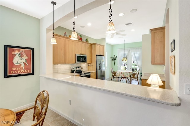 kitchen with appliances with stainless steel finishes, light brown cabinetry, decorative light fixtures, tasteful backsplash, and kitchen peninsula