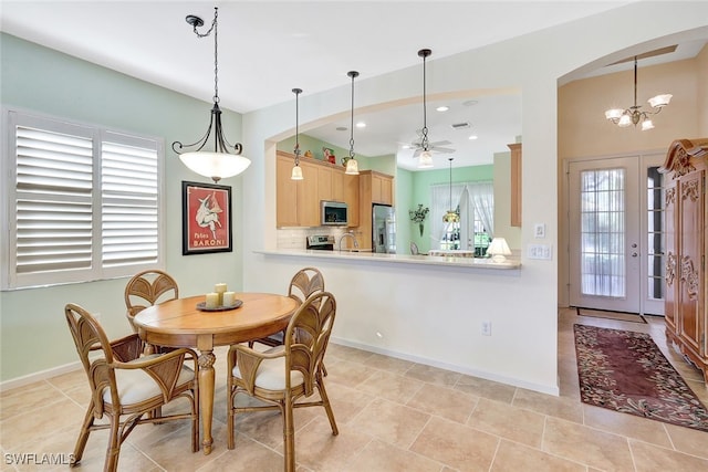 dining area with an inviting chandelier, sink, and light tile patterned floors