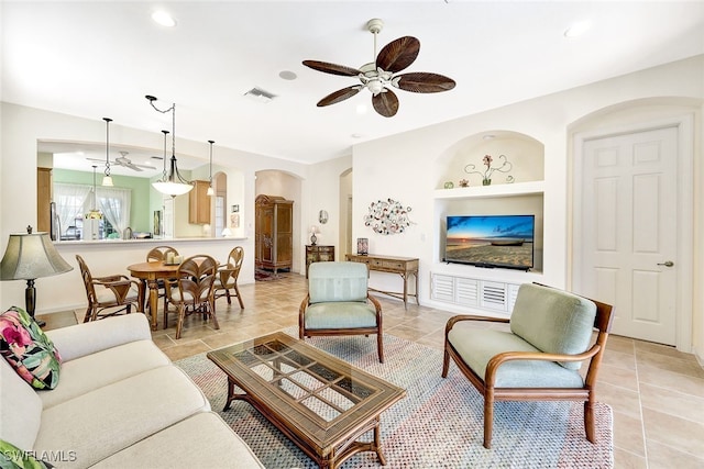 tiled living room featuring built in features and ceiling fan