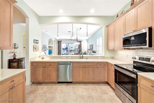 kitchen featuring stainless steel appliances, sink, pendant lighting, and light brown cabinetry