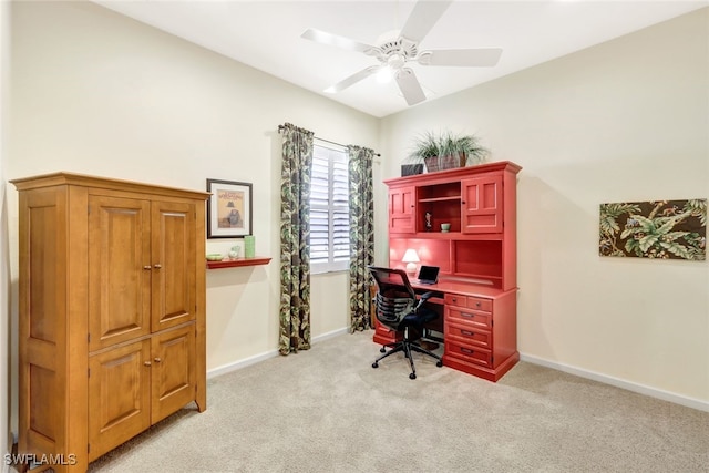 carpeted office space featuring ceiling fan