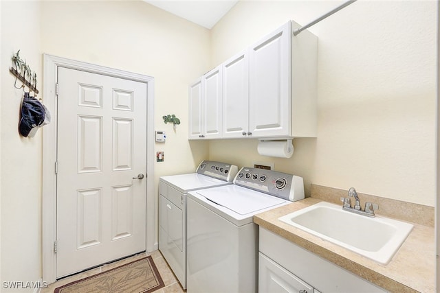 clothes washing area with cabinets, washer and clothes dryer, and sink