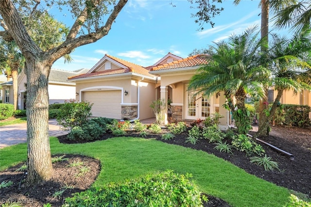 mediterranean / spanish-style house with a garage and a front yard