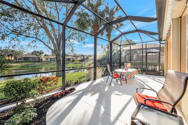 view of patio / terrace with a lanai and a water view