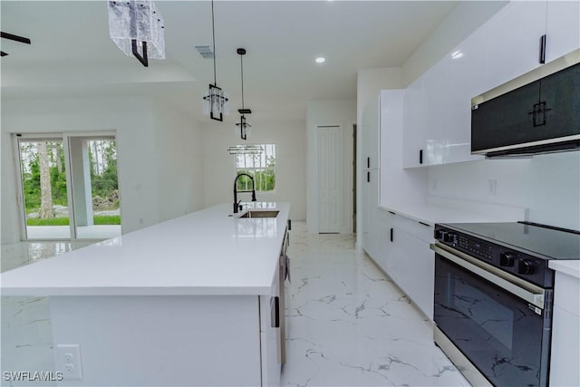 kitchen featuring sink, white cabinetry, decorative light fixtures, an island with sink, and electric stove