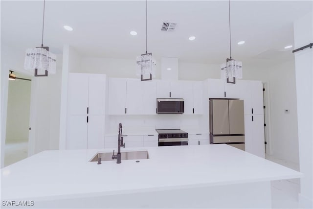 kitchen with sink, decorative light fixtures, and appliances with stainless steel finishes