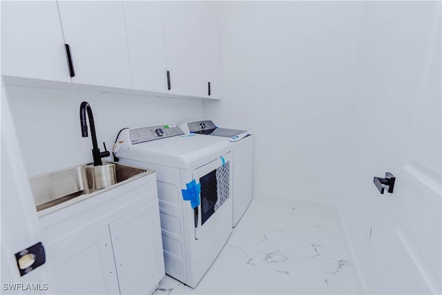 laundry area featuring cabinets, washing machine and dryer, and sink