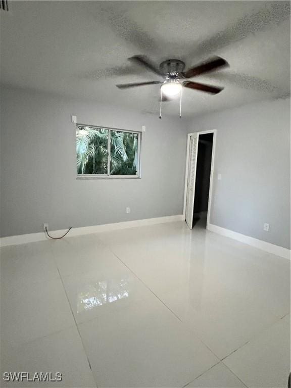 unfurnished room featuring ceiling fan and a textured ceiling