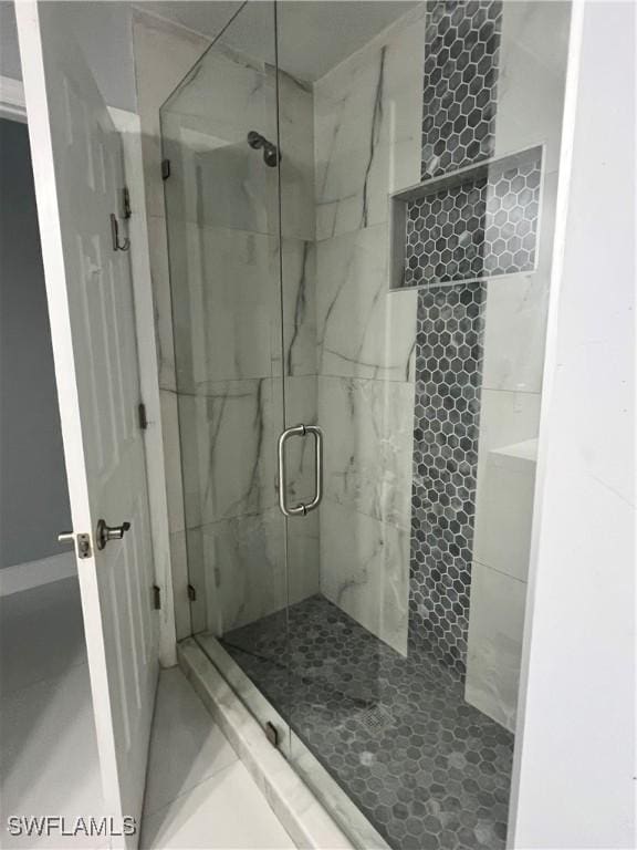 bathroom with a shower with door