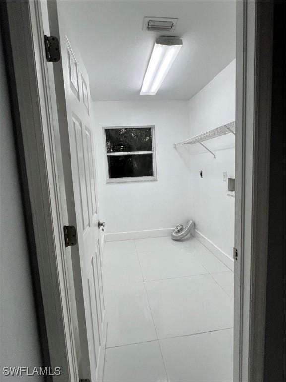 laundry room with electric dryer hookup, light tile patterned floors, and washer hookup