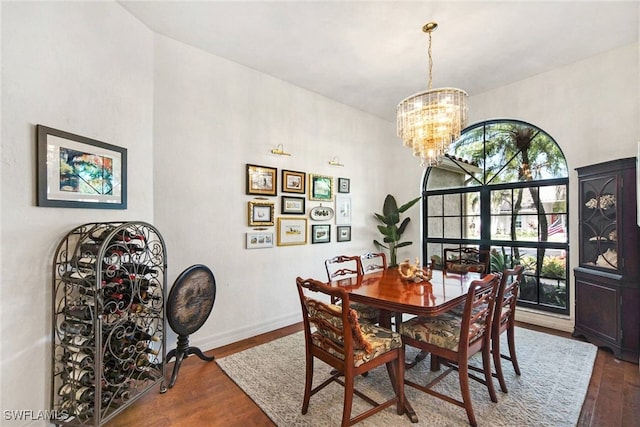 dining area with dark wood-type flooring and a notable chandelier