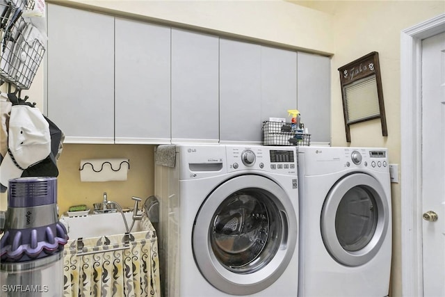 washroom featuring cabinets and independent washer and dryer